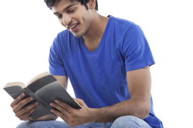 Genç adam beyaz arka planda kitap okumaktan hoşlanıyor.