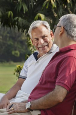 Parkta oturan yaşlı adamlar.