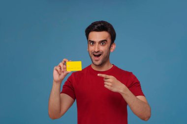 Genç bir adamın portresi elindeki kredi kartına işaret ediyor..