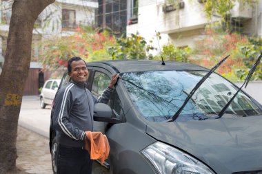 Taksi şoförü arabasını temizliyor.