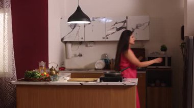 Bir kadın buzdolabına çilek götürüyor ve onları kesmek üzere.