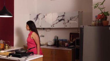 Bir kadın buzdolabına çilek götürüyor ve onları kesmek üzere.