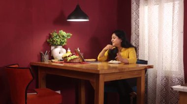 Videoda konuşan ve yemeğinin tadını çıkaran bir kadın.