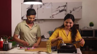 Mutfakta birlikte yemek pişiren çift.