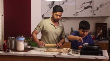 Baba ve oğul tavada şapkalar yapıyor.