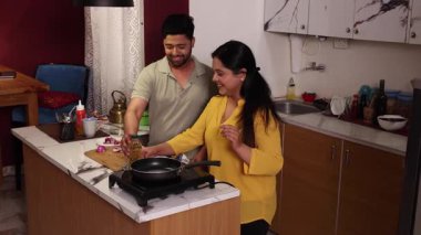 Karı koca birlikte yemek pişirir ve doğrarlar.