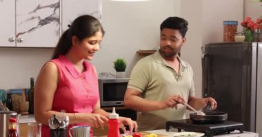 Karı koca birlikte yemek pişirir ve doğrarlar.