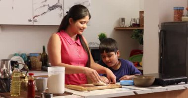 Oğlum mutfakta annesine yardım ediyor ve hamur hazırlıyor.