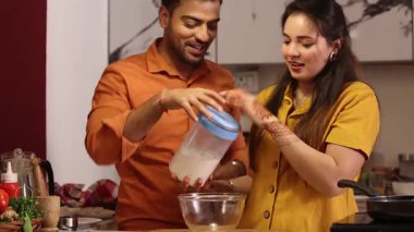 Karı koca mutfakta hamur yoğurmaya hazırlanıyorlar.