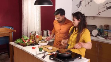 Karı koca Çin yemeklerini pişirirken romantik bir anı paylaşıyorlar.