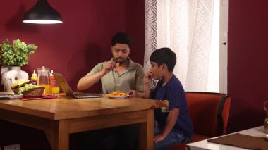 Baba ve oğul abur cuburlarını alıp eğleniyorlar.