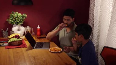 Baba ve oğul abur cuburlarını alıp eğleniyorlar.