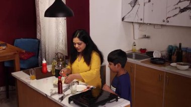 Anne oğluna sandviç hazırlıyor.