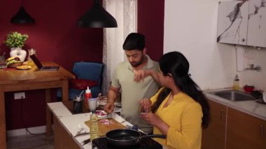 Karı koca birlikte yemek pişirir ve doğrarlar.