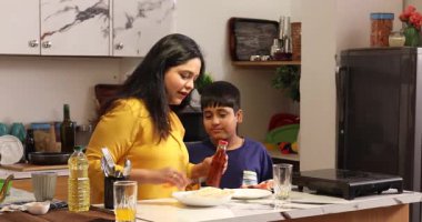 Anne sos şişesini açmaya çalışıyor.