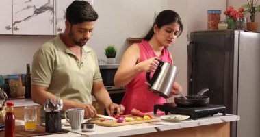 Karı koca birlikte yemek pişirir ve doğrarlar.