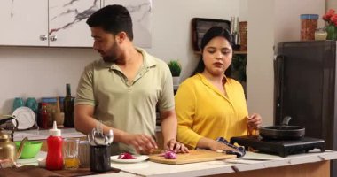 Karı koca birlikte yemek pişirir ve doğrarlar.