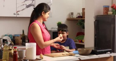 Anne ve oğul birlikte chapatis yapıyor.