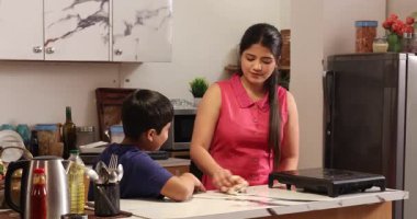 Hem anne hem de oğul mutfak levhasını temizliyor.