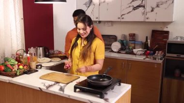 Bir çift, evde mutfakta akşam yemeği için hammadde ve sebze hazırlıyor.