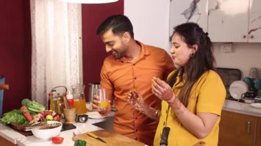 Karı koca meyve suyunu paylaşıyor ve mutfakta romantik bir anın tadını çıkarıyorlar.