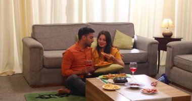 Çiftler doğum gününün tadını çıkarıyor ve birlikte aperatif ve şarap içiyorlar.