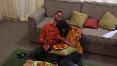 Çift doğum gününün tadını çıkarıyor ve birlikte aperatif ve şarap içiyorlar.