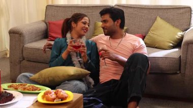 Çift doğum gününün tadını çıkarıyor ve birlikte aperatif ve şarap içiyorlar.