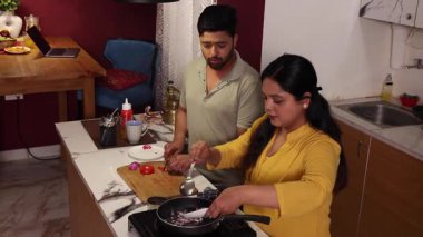 Karı koca tavada sebze soteleniyor.