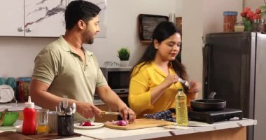 Karı koca birlikte yemek pişirir ve doğrarlar.