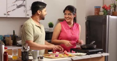 Karı koca tavada sebze doğruyor ve soteleniyor.