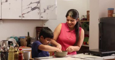 Oğlum mutfakta annesine yardım ediyor ve hamur hazırlıyor.