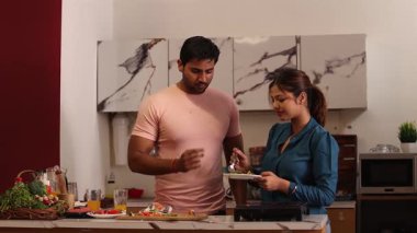 Mutfakta erişte yiyen bir kadın var.