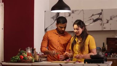 Hintli çift mutfak tezgahında ailelerine yemek hazırlıyor.