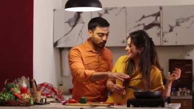 Lezzetli, gurme ve sağlıklı yemek kokusu alan çift mutfakta konuşuyor. Romantizm, kucaklaşma ve kadın ve erkek yemek hazırlıyor, eğleniyor ve birlikte vakit geçiriyorlar.