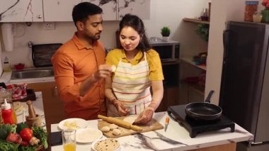 Mutlu çift mutfakta birlikte chapati yapıyor.