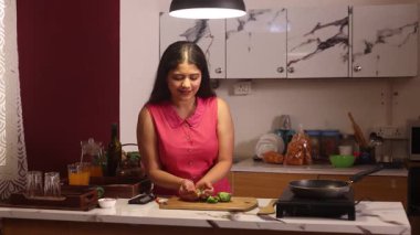 Müziğin tadını çıkarırken yemek yapan bir kadın.