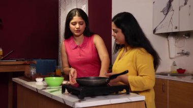 İki kadın dedikodu yaparken yemek pişiriyor ve abur cuburlarının tadını çıkarıyor.