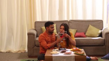 Çiftler doğum gününün tadını çıkarıyor ve birlikte aperatif ve şarap içiyorlar.