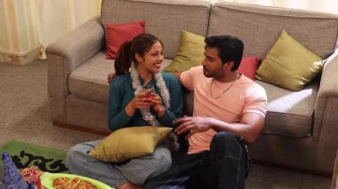 Çift doğum gününün tadını çıkarıyor ve birlikte aperatif ve şarap içiyorlar.