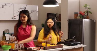 İki kadın birlikte temizlik ve yemek yapıyor.