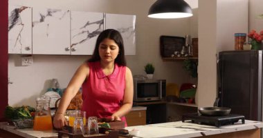 Müziğin tadını çıkarırken yemek yapan bir kadın.