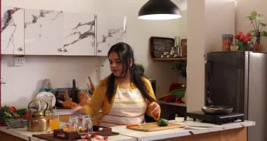 Bir kadın yemek pişiriyor ve doğruyor.