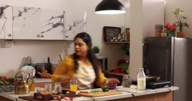 Telefonla konuşurken kahvaltının tadını çıkaran bir kadın.