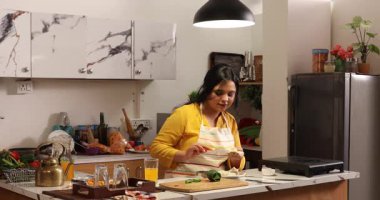 Bir kadın kendine sandviç yapıyor ve onu yiyor.