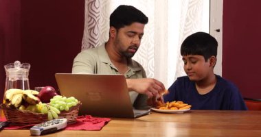 Baba ve oğul abur cuburlarını alıp eğleniyorlar.