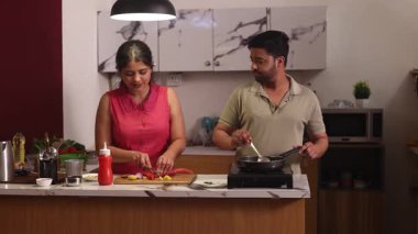 Koca karısını pişiriyor sebzeleri doğruyor.