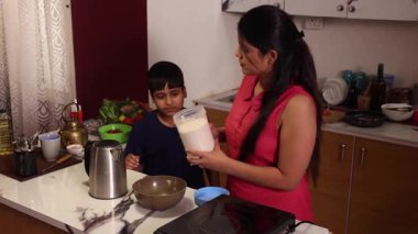 Anne ve oğul hamur hazırlıyor ve birbirlerine sataşıyorlar.