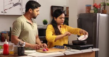 Karı koca tavada sebze doğruyor ve soteleniyor.