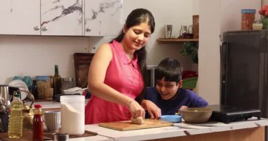 Oğlum mutfakta annesine yardım ediyor ve hamur hazırlıyor.